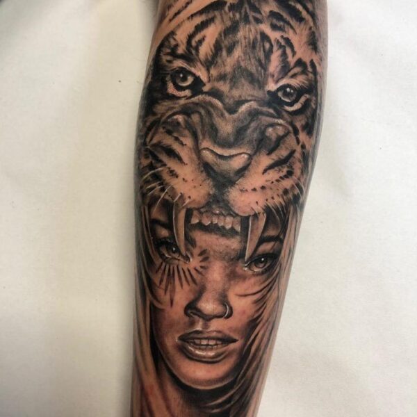 Vikinga tattoo Tatuaje de una mujer vikinga con un tigre en la cabeza estilo realismo en la pierna