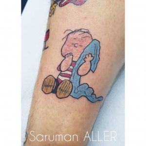 tatuaje estilo old school de Linus van pelt en la pierna