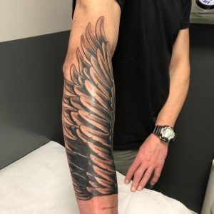 Tatuaje de una ala estilo realismo en el antebrazo