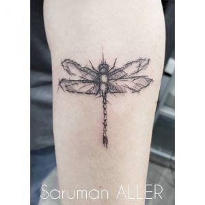 tatuaje libélula minimalista en el brazo