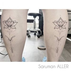 Tatuaje minimalista de una flor en los gemelos con trazos y lineas finas