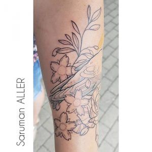 Tatuaje minimalista a un solo color flores y pájaro