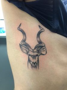 Tatuaje de un reno estilo minimalista en la costilla