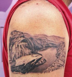tatuaje de paisaje de un río en el brazo
