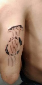 tatuaje de cuerdas de guitarra minimalista