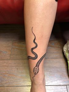 serpiente realista enrollada en la pierna