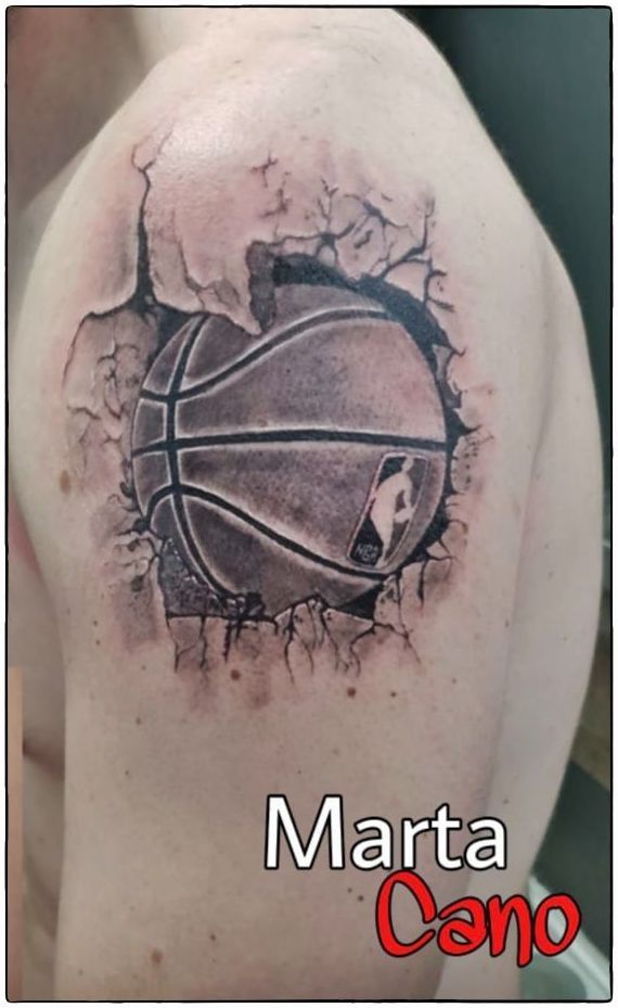 Tatuaje de un balón rompiendo la piel estilo realismo o en el brazo