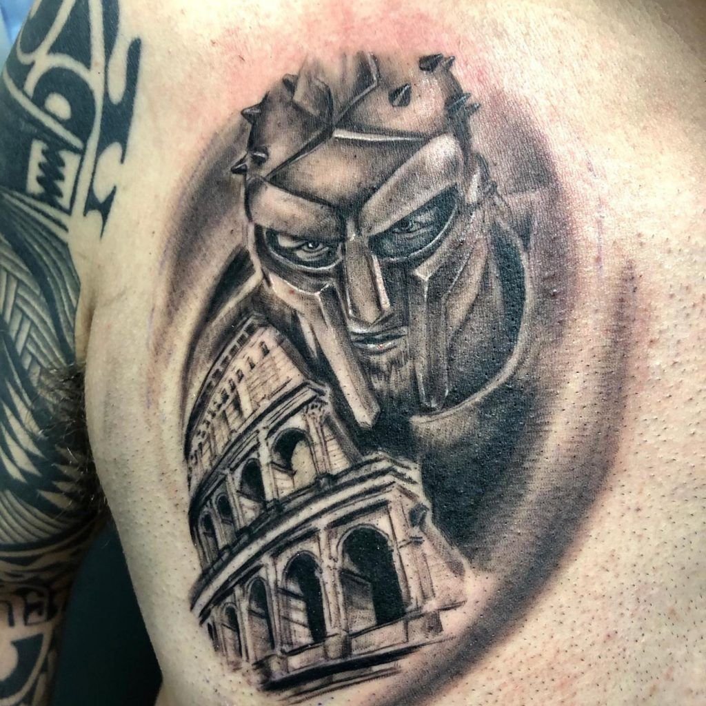 Tatuaje de un gladiador con parte de la fachada del coliseo estilo realismo en el pecho
