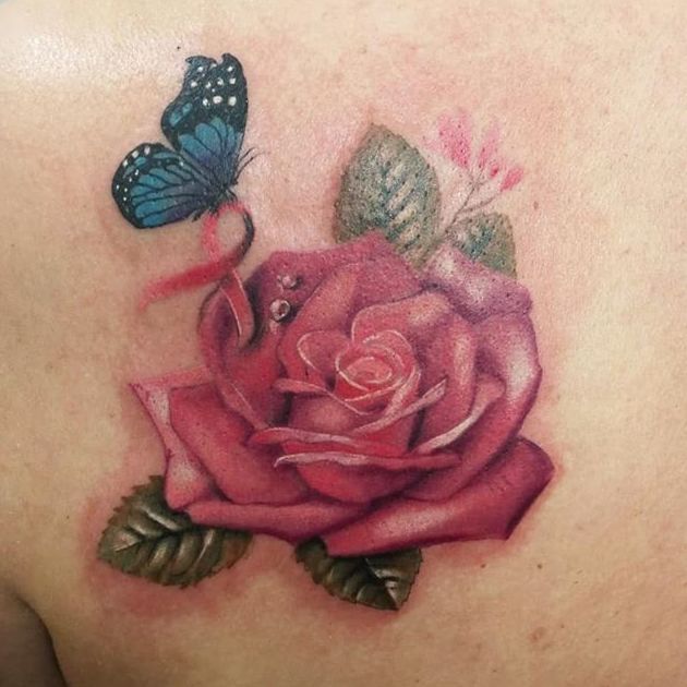 Tatuaje rosa con una mariposa azul sosteniendo un lazo estilo realismo a color