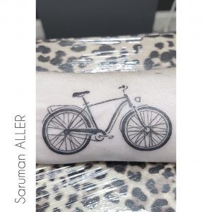 Tatuaje minimalista de una bicicleta en el brazo