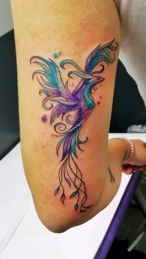 Tatuaje ave fénix a color en el brazo