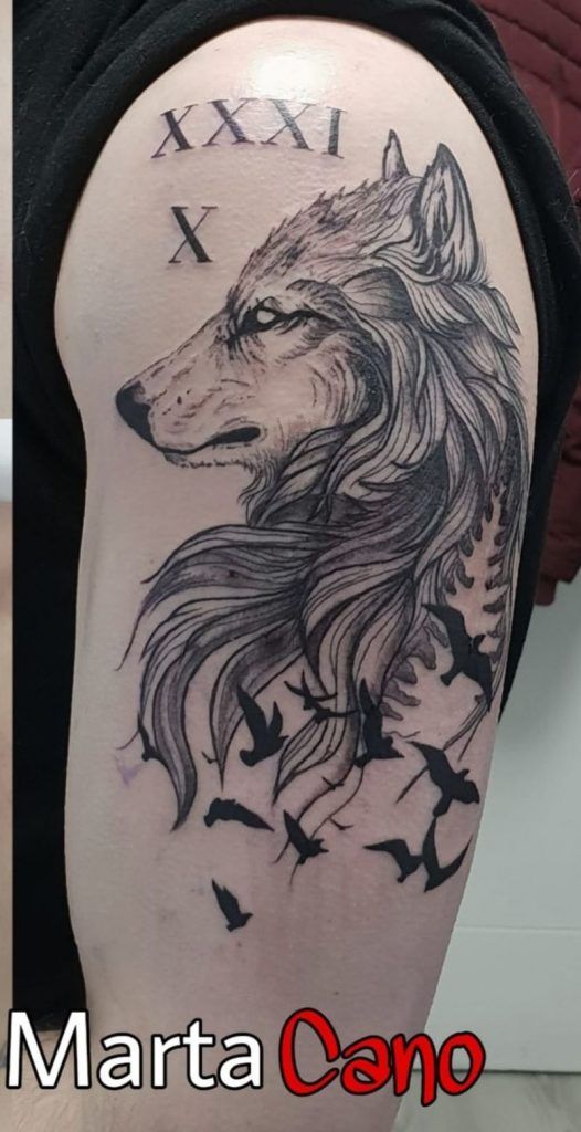 tatuaje lobo con pajaritos volando en el brazo