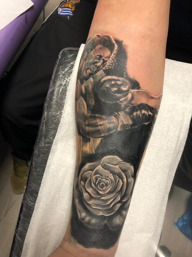 Tatuaje dos boxeadores con una rosa estilo realismo en el antebrazo
