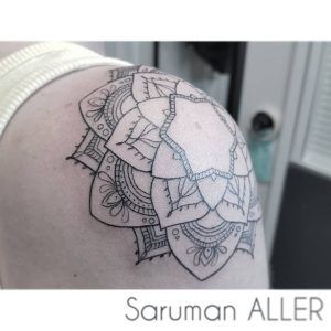 tatuaje minimalista de una flor en el hombro