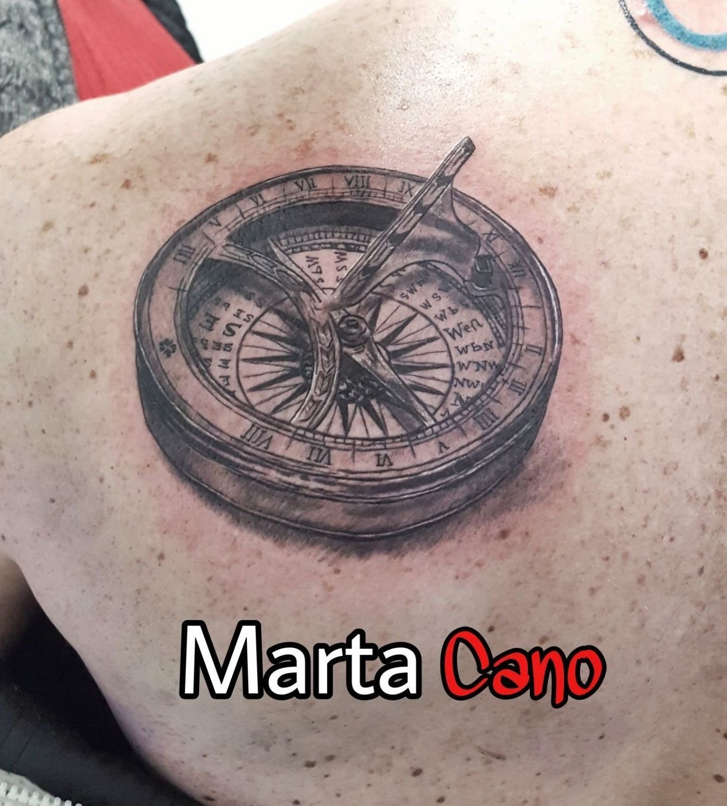 tatuaje realista de una brújula en la espalda