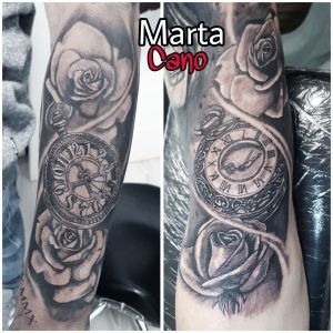 tatuaje realista de un reloj con rosas en el brazo