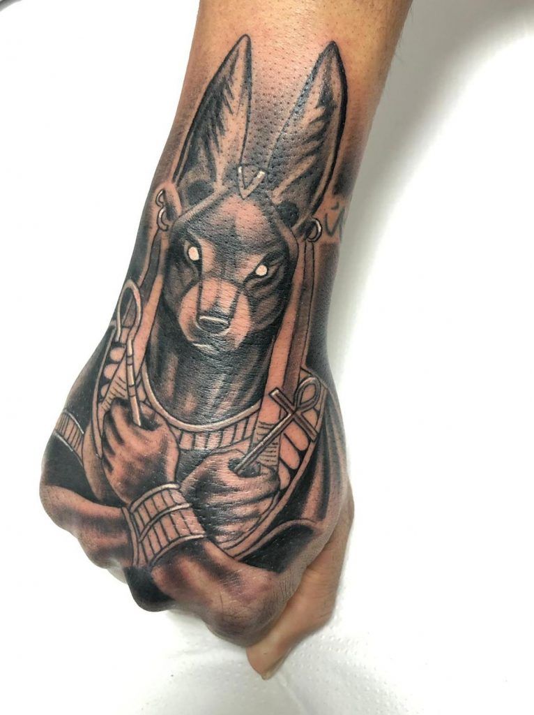 Tatuaje del guardián de las tumbas Anubis estilo realismo en la mano
