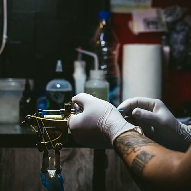Tatuador arreglando una maquina de tatuar