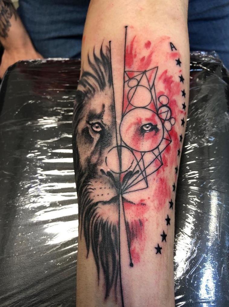 Tatuaje león geométrico estilo trash polka en el antebrazo
