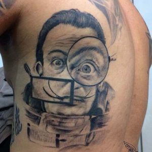 Tatuaje retrato del pintor Salvador Dalí estilo realismo en las costillas