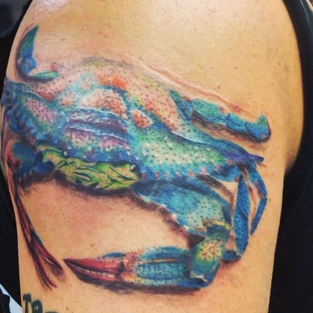 Tatuaje de un cangrejo estilo realismo a color en el brazo