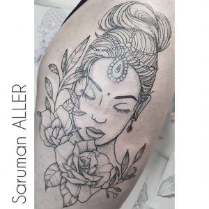 Tatuaje minimalista de una mujer junto a flores y puntillismo