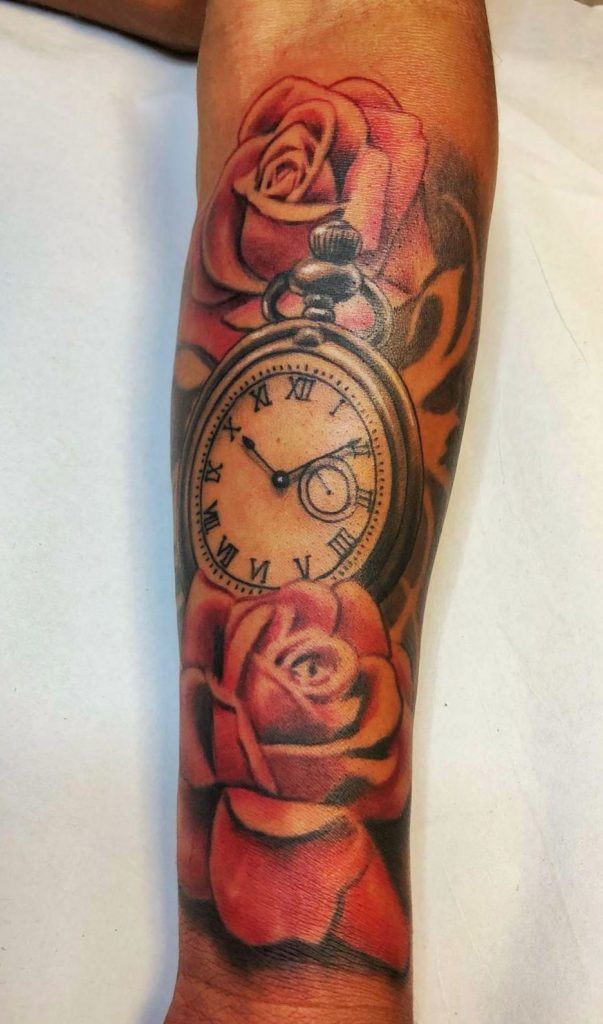 Tatuaje de un reloj rodeado de rosas en el antebrazo