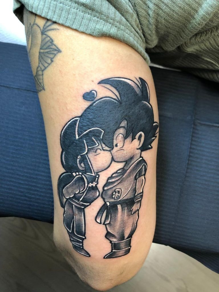 Tatuaje de dos personajes de Goku besándose estilo comic en la parte trasera del brazo