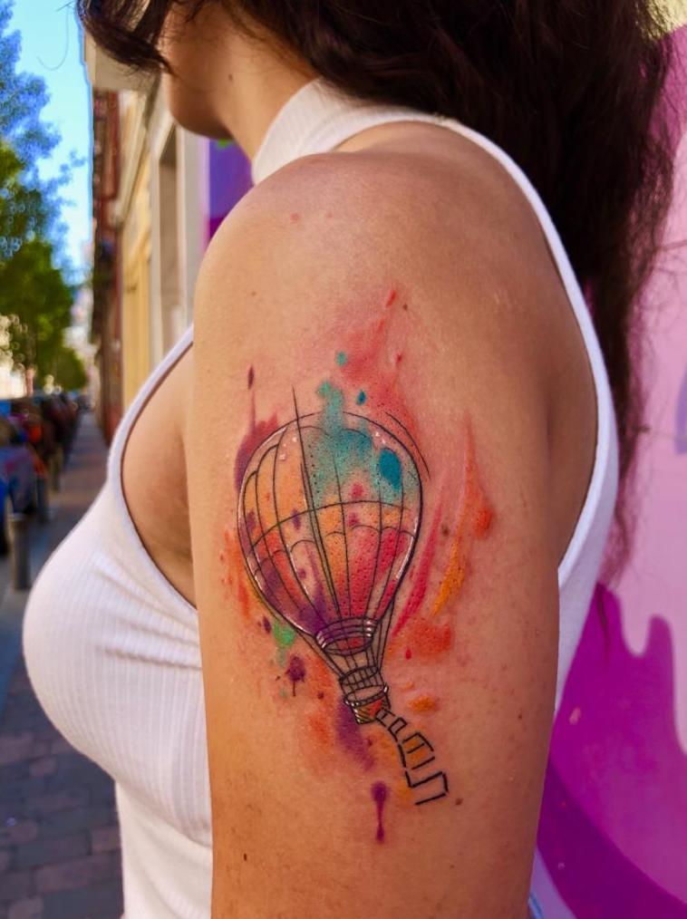 Tatuaje de un globo estilo watercolor en el brazo