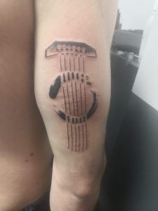 tatuaje minimalismo cuerdas de guitarra