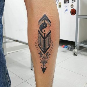 Tatuaje geométrico con la incorporación del elemento Yin y el Yang en la pierna