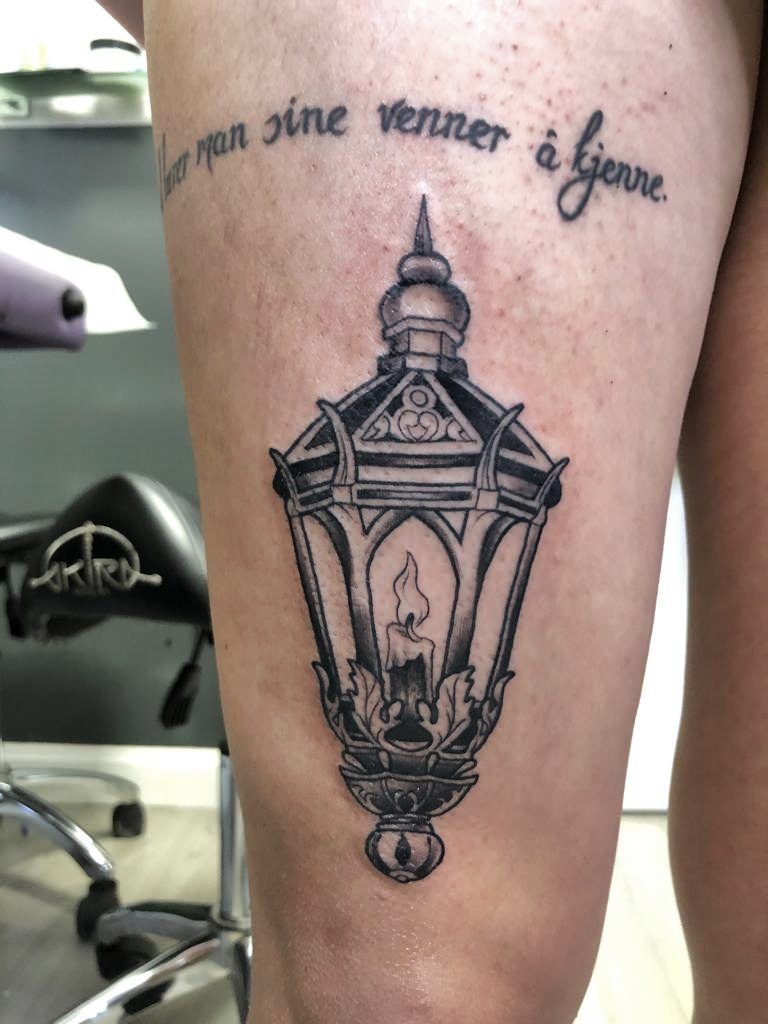 tatuaje de faro con una vela dentro
