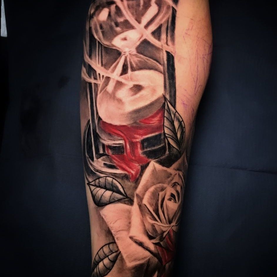 tatuaje de un reloj de arena y una rosa en el antebrazo