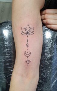 Tatuaje flor de loto en el brazo estilo minimalista