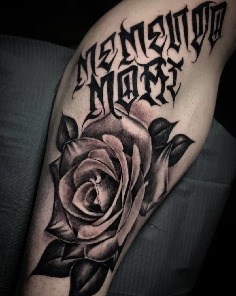 Tatuaje realista de una rosa con lettering.