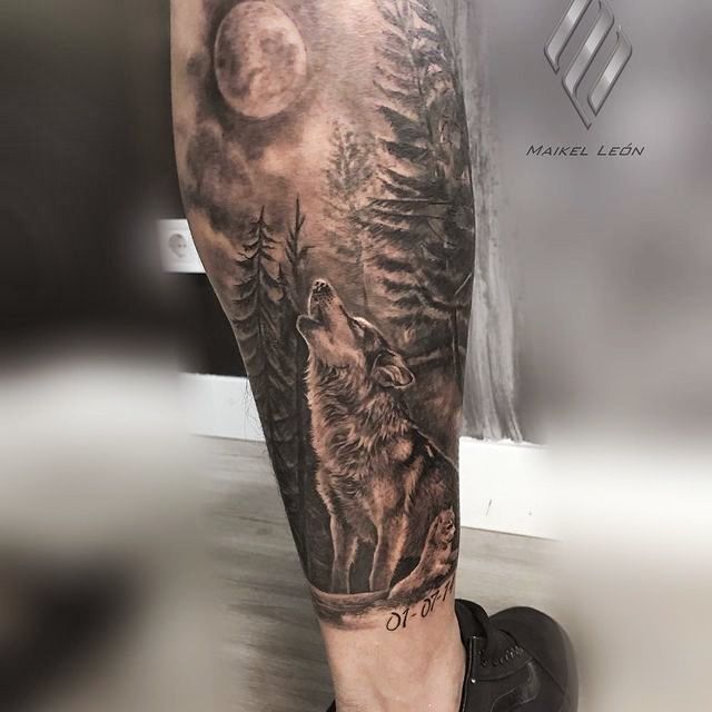 Tatuaje lobo con paisaje estilo realismo en la pierna.