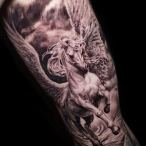 Caballo con cuernos y alas estilo realismo en el brazo