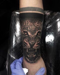 tatuaje de un tigre con la boca abierta en el antebrazo estilo realista
