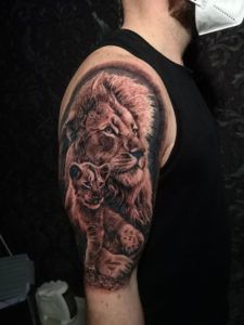 Tatuaje león y su cachorro estilo realista en el brazo