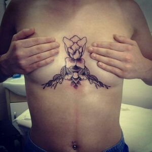 tatuaje de una rosa en el pecho de una mujer
