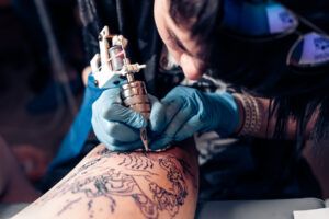 tatuador realizando tatuaje lineas finas