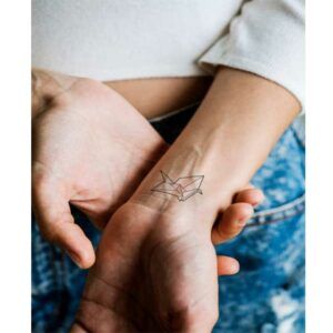 tatuaje origami de línea fina para mujer en la muñeca de tamaño pequeño
