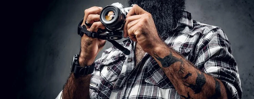 hombre tatuado tomando una fotografía