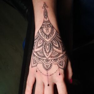 Tatuaje mándala de línea fina en la mano