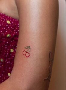 tatuaje minimalista cerezas brazo