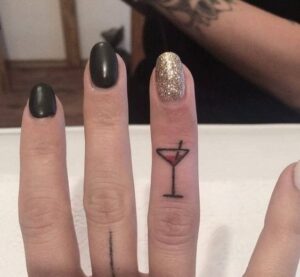 tatuaje copa de coctel minimalista en dedo