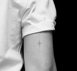 tatuaje minimalista estrella en parte atrás brazo