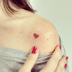 tatuaje minimalista corazón rojo degradado en el hombro