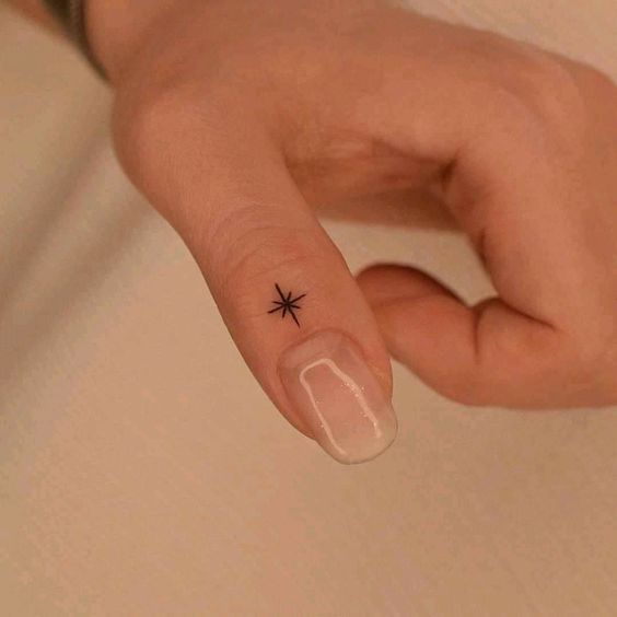 tatuaje minimalista estrella en el dedo pulgar