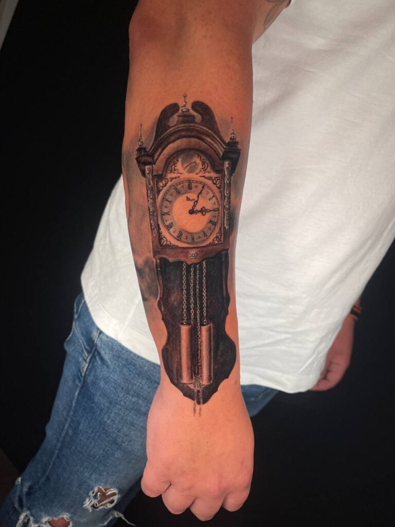 tatuaje de reloj antiguo en el antebrazo estilo realista